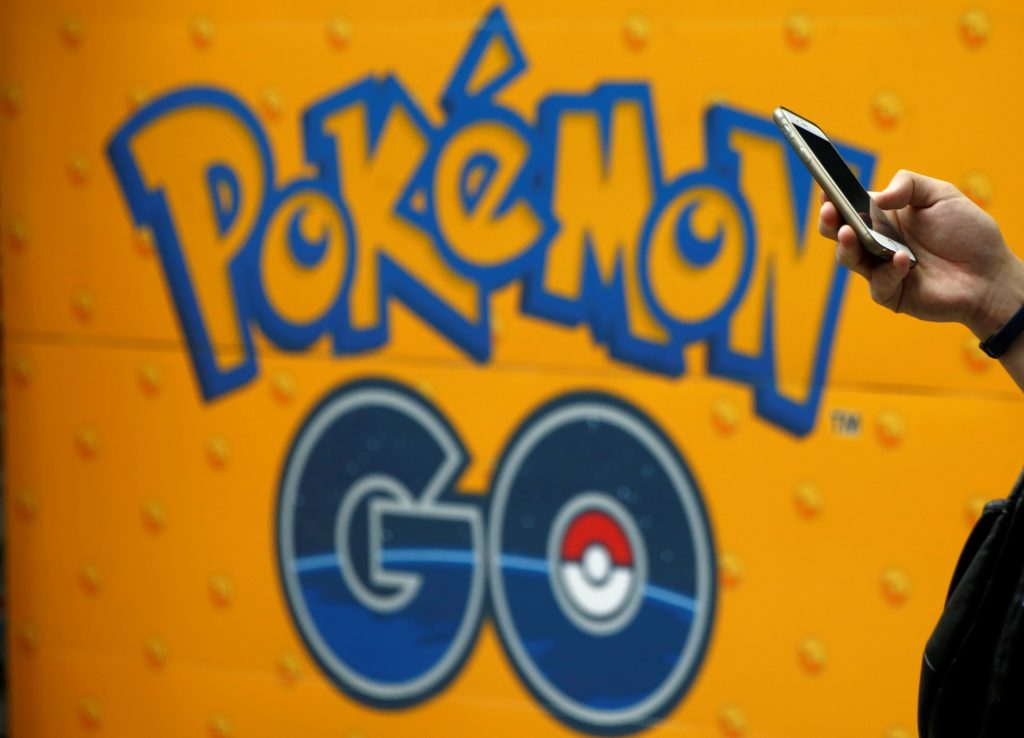 A man uses a mobile phone in front of an advertisement board bearing the image of Pokemon Go at an electronic shop in Tokyo, Japan, July 27, 2016.   REUTERS/Kim Kyung-Hoon/File Photo