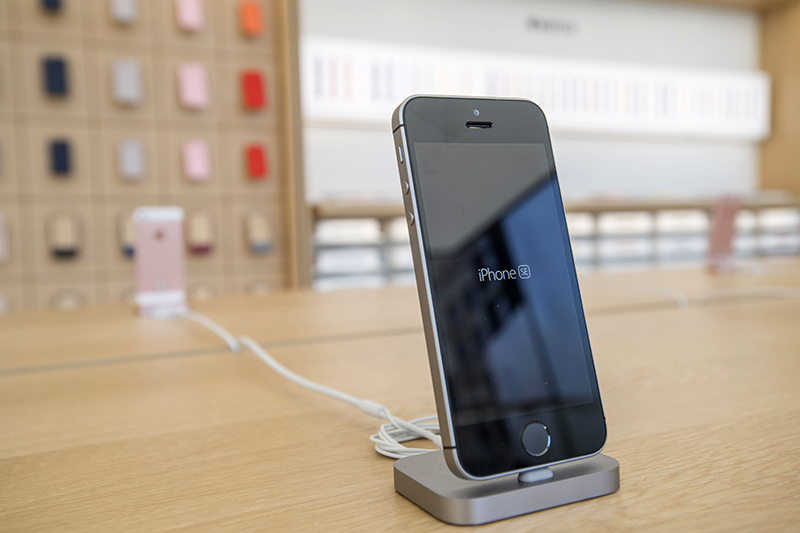 An Apple Inc. iPhone SE smartphone is displayed inside the company's new flagship store at Union Square in San Francisco, California, U.S., on Thursday, May 19, 2016. The flagship location, opening Saturday on San Francisco's Union Square, boasts 40-foot-tall doors opening onto the square and comprises five departments, or what Apple prefers to call "features." Photographer: David Paul Morris/Bloomberg